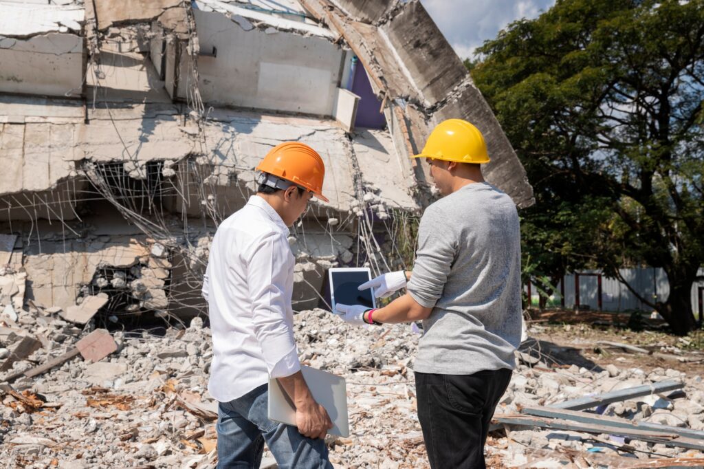 Demolition control supervisor and foreman discussing on demolish building.